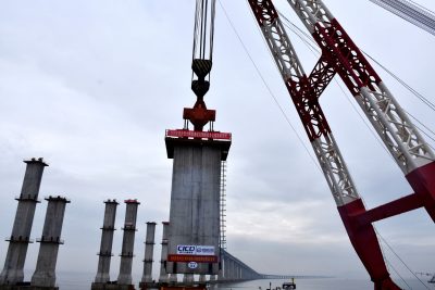 An aerial view of cranes standing on boats erecting piers of the Zhoudai Bridge, Zhoushan city, east China’s Zhejiang province, 23 December 2020 (Photo: Reuters/Yao Feng).